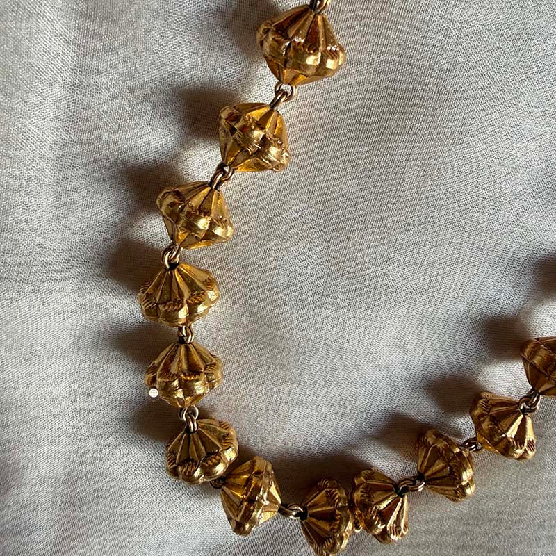 Exquisite gold necklace with unique faceted beads.