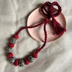 Beaded chandi ki bangles with red tassel detail.