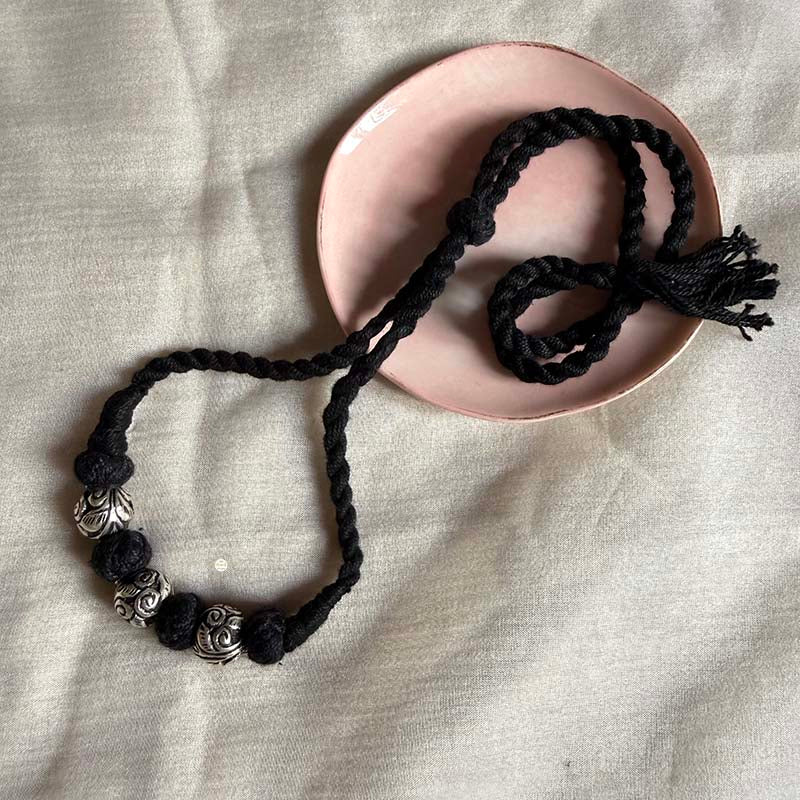 Braided black thread silver jewlery with carved beads.